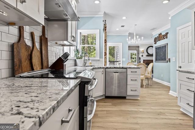 kitchen featuring white cabinetry, decorative backsplash, light stone countertops, ventilation hood, and appliances with stainless steel finishes