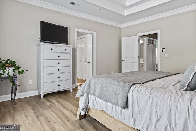 bedroom featuring a closet, crown molding, and light hardwood / wood-style flooring