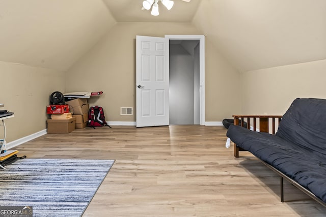 living area with vaulted ceiling and light hardwood / wood-style flooring