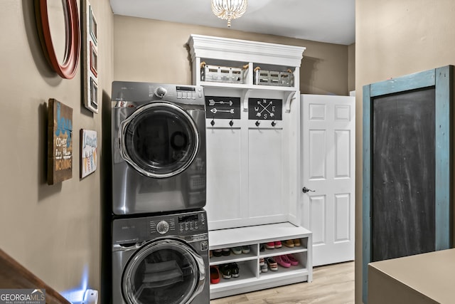 clothes washing area with light hardwood / wood-style floors and stacked washer and dryer