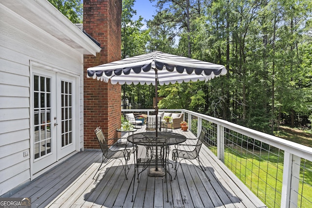 wooden deck featuring french doors and a lawn