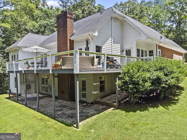 rear view of property featuring a lawn and a wooden deck