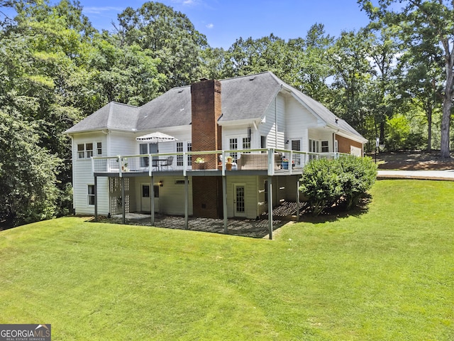 back of property with a deck and a yard