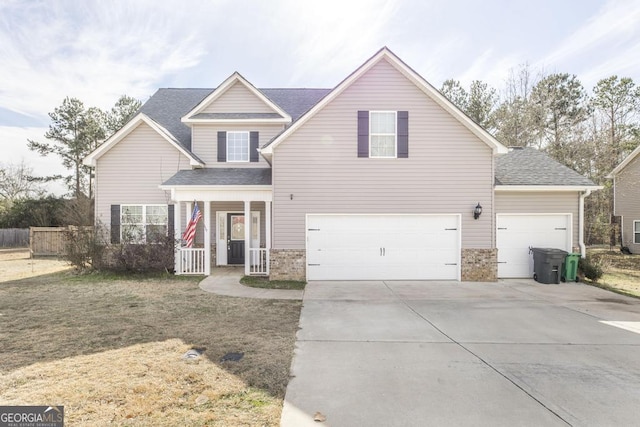 front facade featuring covered porch, a front lawn, and a garage