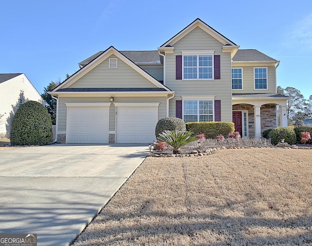 traditional home with a garage, stone siding, and driveway