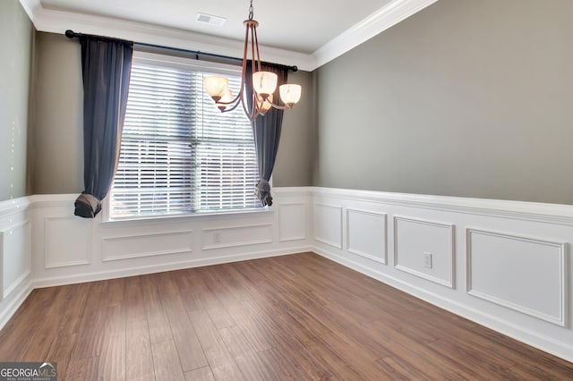 unfurnished dining area with visible vents, an inviting chandelier, dark wood-style flooring, wainscoting, and crown molding