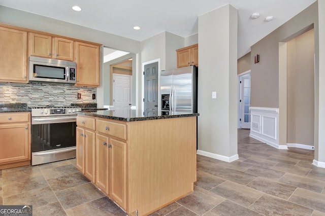 kitchen featuring dark stone countertops, tasteful backsplash, appliances with stainless steel finishes, and light brown cabinets