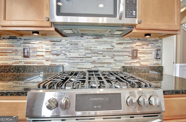 interior details featuring dark countertops, backsplash, light brown cabinets, and appliances with stainless steel finishes