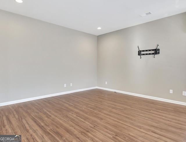 unfurnished room featuring visible vents, baseboards, and wood finished floors