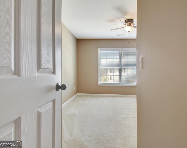 carpeted empty room featuring visible vents, baseboards, and a ceiling fan