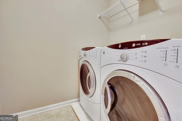 washroom featuring light tile patterned flooring, laundry area, independent washer and dryer, and baseboards