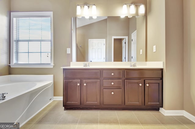 bathroom with tile patterned floors, baseboards, a garden tub, and double vanity