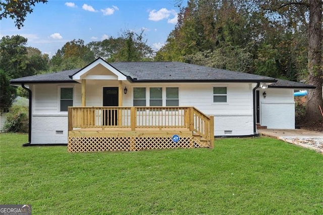 rear view of property with a yard, a wooden deck, and a garage