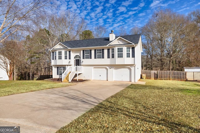 raised ranch featuring a front yard and a garage