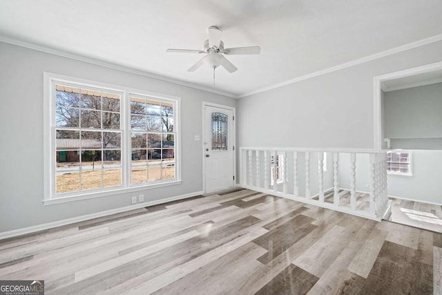 empty room featuring ceiling fan, light hardwood / wood-style floors, crown molding, and a wealth of natural light