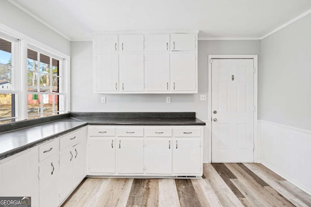 kitchen with white cabinets, light hardwood / wood-style floors, and crown molding