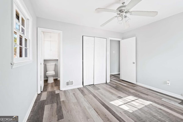 unfurnished bedroom with connected bathroom, a closet, ceiling fan, and light hardwood / wood-style floors