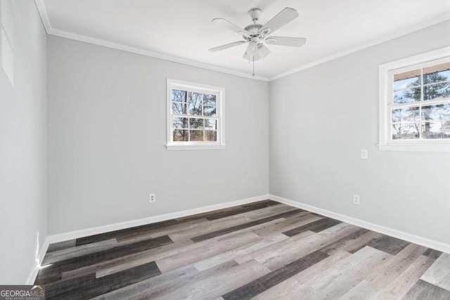 empty room with ornamental molding, ceiling fan, a wealth of natural light, and wood-type flooring