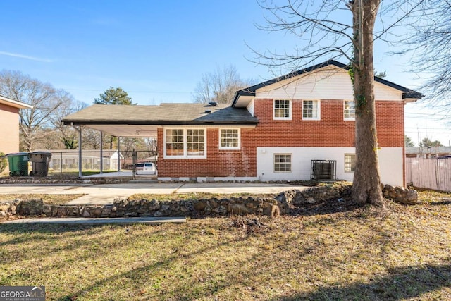 back of property with cooling unit, a carport, and a lawn