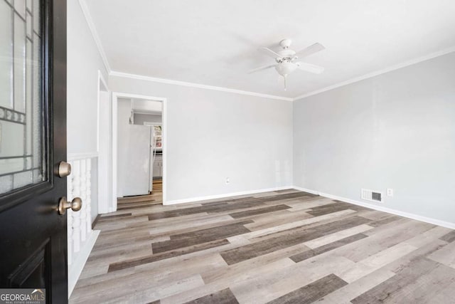 empty room with ceiling fan, crown molding, and wood-type flooring