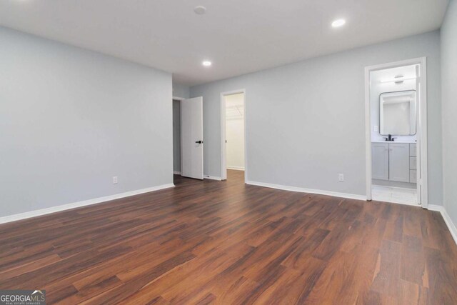 unfurnished room with sink and dark wood-type flooring