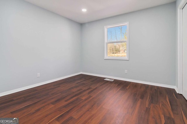 unfurnished room with dark hardwood / wood-style flooring