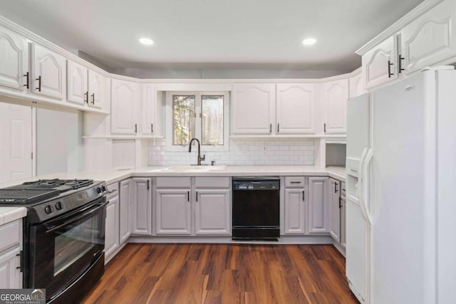 kitchen with black appliances, dark hardwood / wood-style flooring, white cabinets, backsplash, and sink