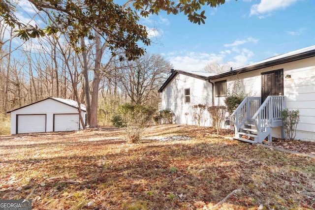 view of yard featuring a garage and an outbuilding