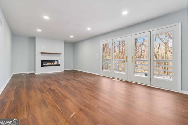 unfurnished living room featuring french doors and dark hardwood / wood-style flooring