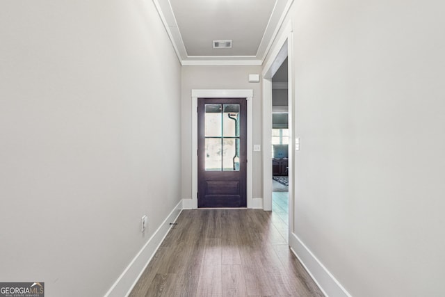 entryway with ornamental molding and hardwood / wood-style flooring