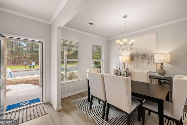 dining space featuring a chandelier, crown molding, and light hardwood / wood-style flooring