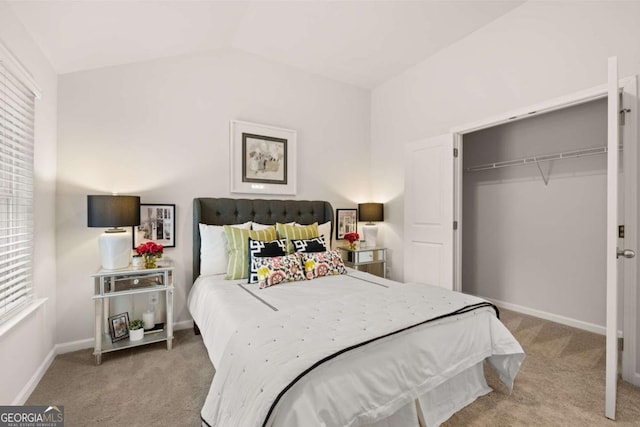 bedroom featuring vaulted ceiling, light carpet, and a closet