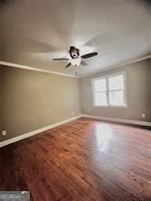 empty room with ceiling fan, hardwood / wood-style floors, and ornamental molding