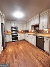 kitchen featuring hardwood / wood-style flooring, appliances with stainless steel finishes, and white cabinetry