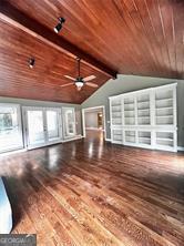 unfurnished living room featuring ceiling fan, hardwood / wood-style floors, wood ceiling, and vaulted ceiling with beams