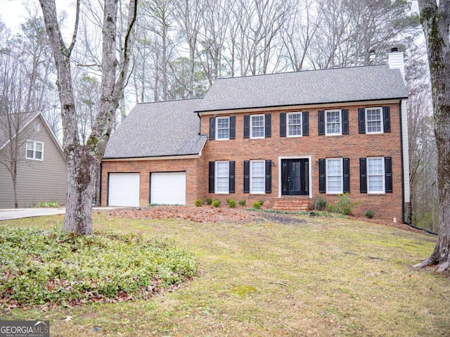 colonial inspired home featuring a garage and a front yard