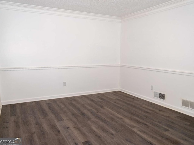 empty room with a textured ceiling, crown molding, and dark hardwood / wood-style floors