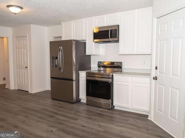 kitchen with dark hardwood / wood-style flooring, white cabinetry, a textured ceiling, and appliances with stainless steel finishes