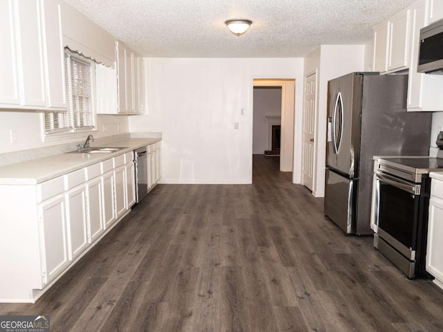 kitchen featuring white cabinets, a textured ceiling, appliances with stainless steel finishes, and sink