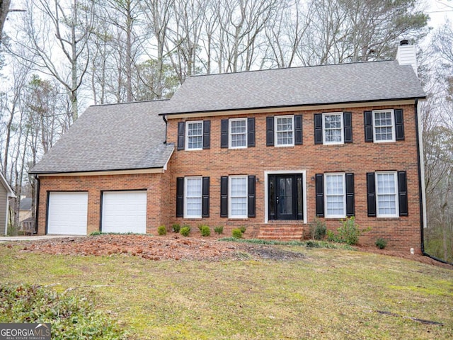 colonial house with a front yard and a garage