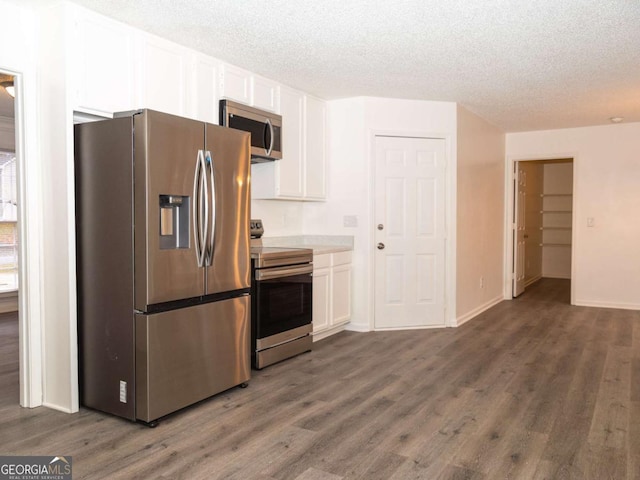 kitchen featuring dark hardwood / wood-style flooring, white cabinetry, a textured ceiling, and appliances with stainless steel finishes