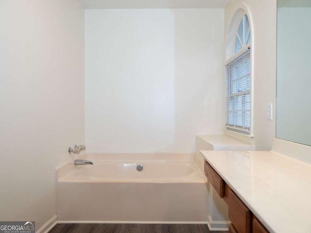 bathroom with a bathtub, wood-type flooring, and vanity