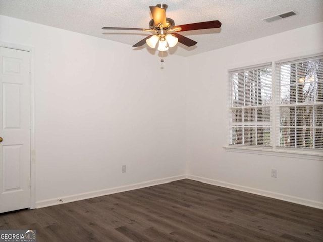 spare room with ceiling fan, dark wood-type flooring, and a textured ceiling