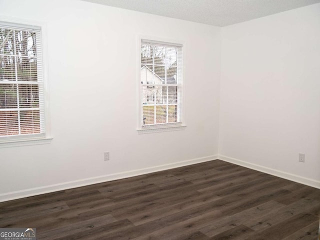 unfurnished room featuring a textured ceiling and dark wood-type flooring