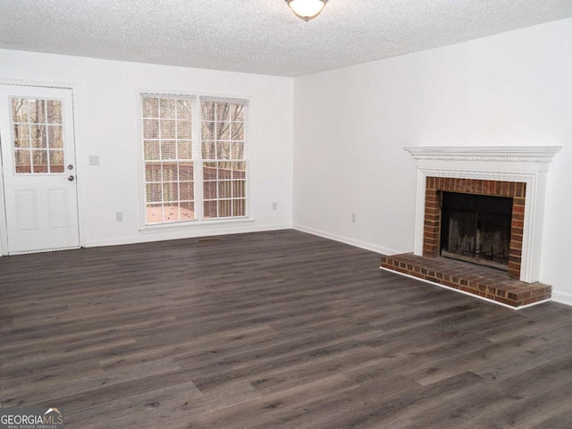 unfurnished living room featuring a textured ceiling, plenty of natural light, dark hardwood / wood-style floors, and a fireplace