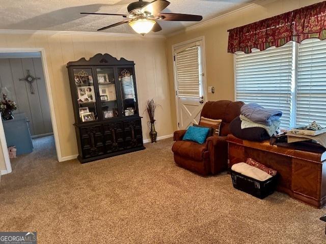 living area featuring ornamental molding, a textured ceiling, carpet floors, and ceiling fan