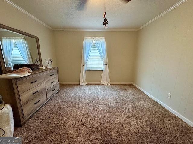 interior space with a textured ceiling, ceiling fan, carpet, and crown molding