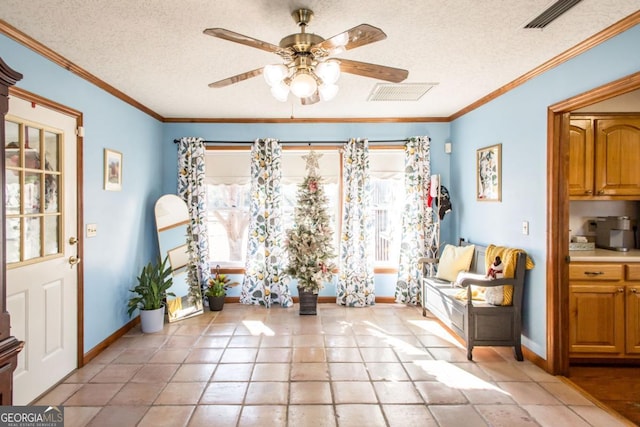 interior space featuring a textured ceiling, ceiling fan, light tile patterned floors, and ornamental molding