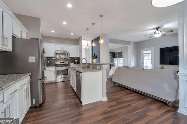 kitchen with appliances with stainless steel finishes, pendant lighting, white cabinetry, and sink