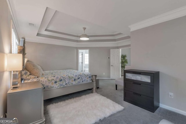 carpeted bedroom with a raised ceiling, ceiling fan, and ornamental molding